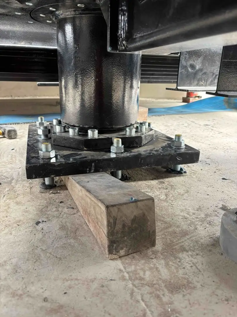 Cylindrical pivot support and bolted base plate beneath the bridge.
