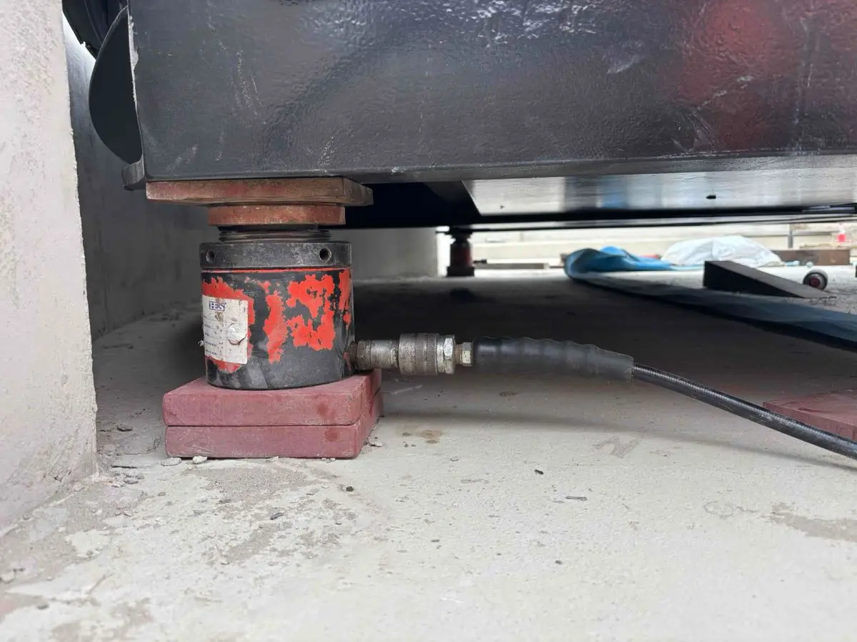Hydraulic jack and packing plates supporting the underside of the bridge.
